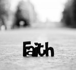 A cut out of the word "Faith" on a street.